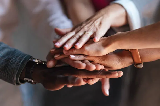 Team members stacking their hands together